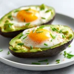 Awokado z jajkiem w air fryer podane na talerzu.