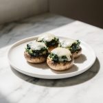 Faszerowane pieczarki z Air Fryer na talerzu, idealne na przekąskę.